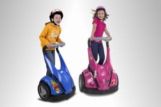 Two children riding blue and pink Feber Dareway scooters.
