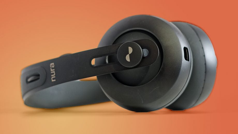 Close-up of Nuraphone headphones on orange background.