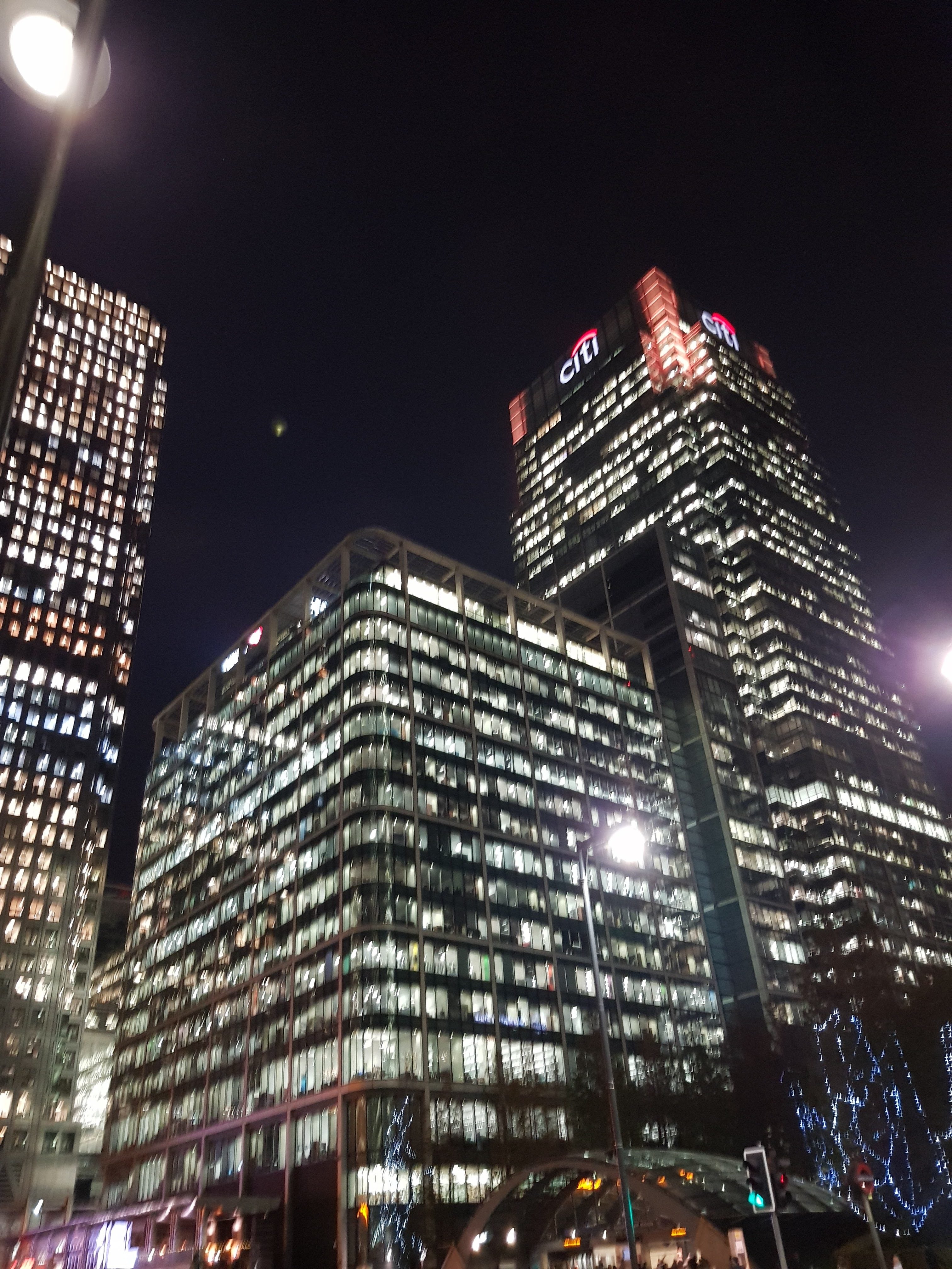 Nighttime cityscape with illuminated office buildings.