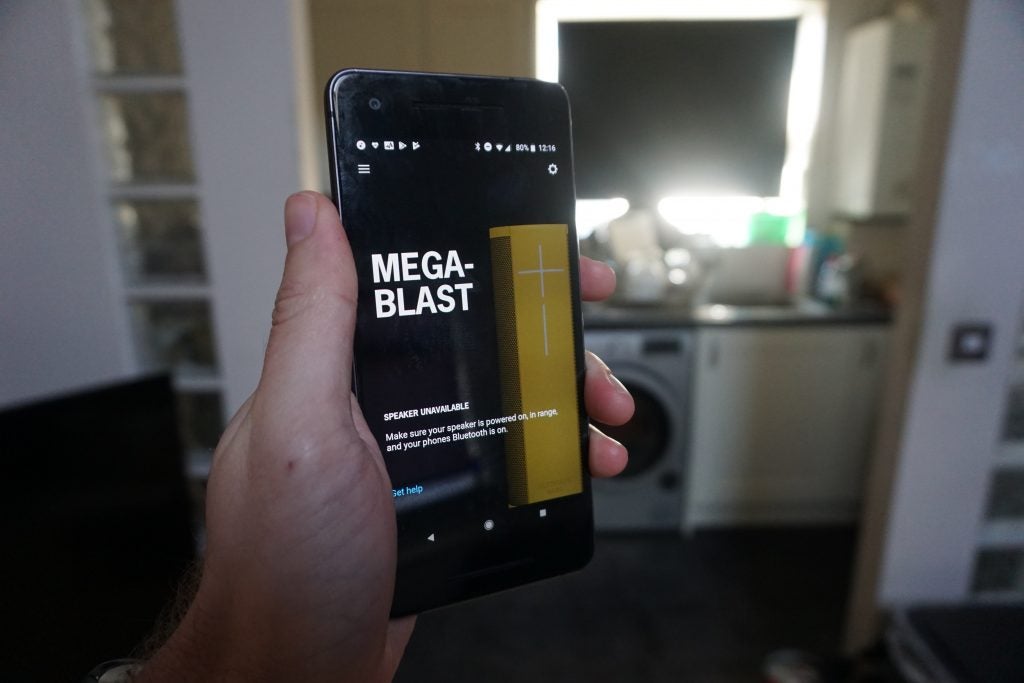 Hand holding smartphone displaying UE Megablast speaker error message.