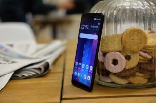 HTC U11+ smartphone on table with cookies in background