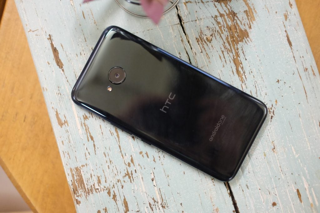 HTC U11 Life smartphone on a distressed wooden table.