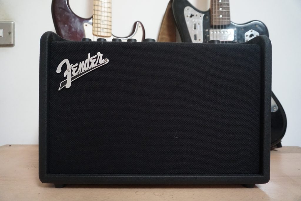 Fender Mustang GT 40 amplifier with guitars in background.