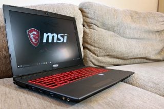 MSI GV62 7RC laptop with backlit keyboard on couch.