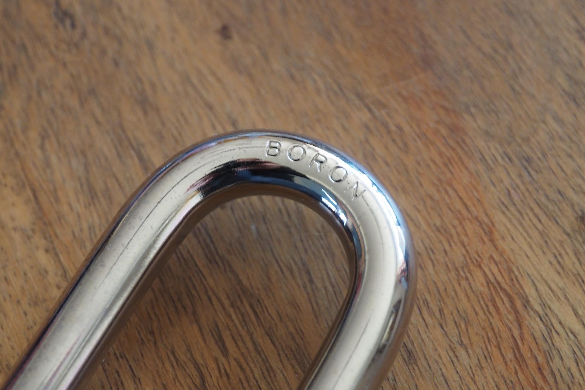 Master Lock Smart Outdoor Padlock secured to a wooden gate.Close-up of a padlock shackle with engraved word 