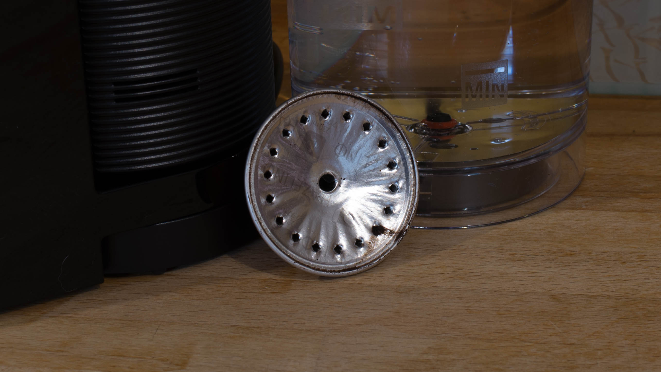 Used Nespresso Vertuo capsule with coffee machine background.