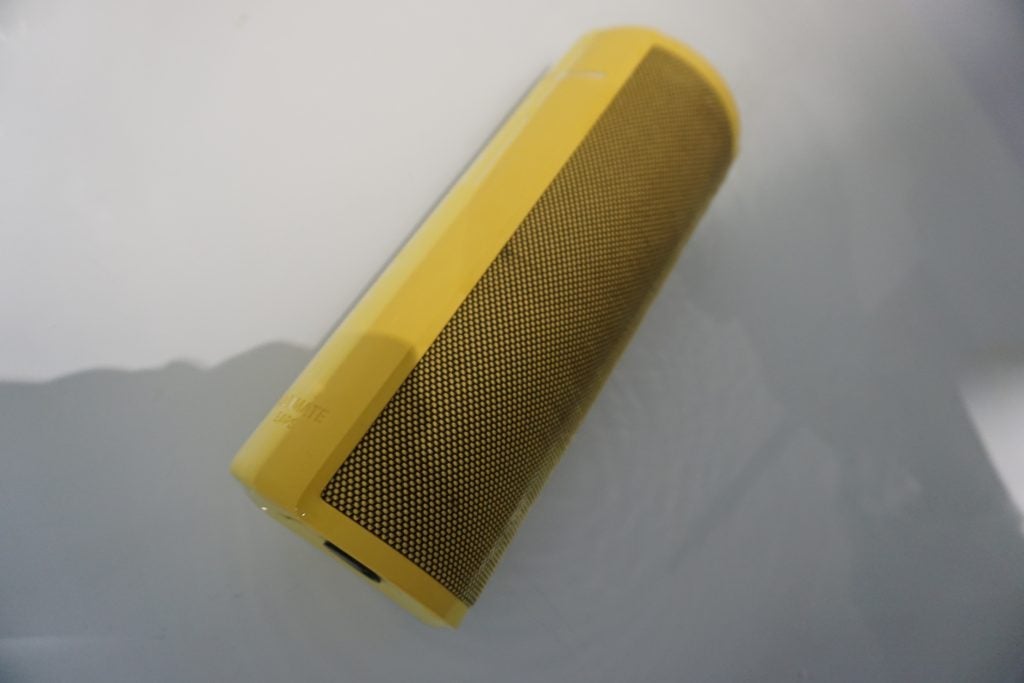 Yellow UE Megablast speaker on white surface.