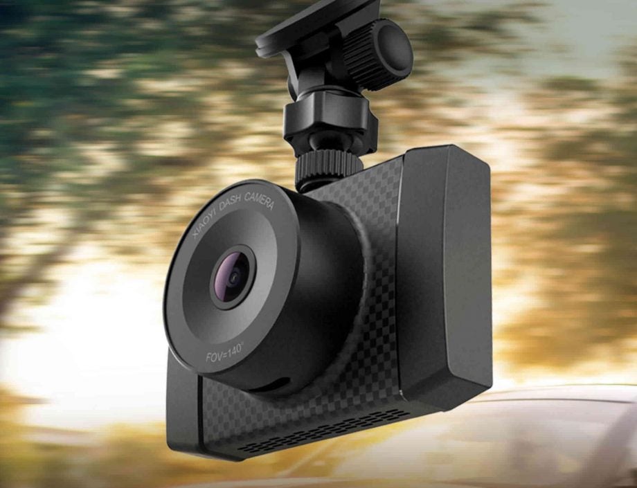 Yi Ultra Dash Camera mounted in vehicle with blurred road background.