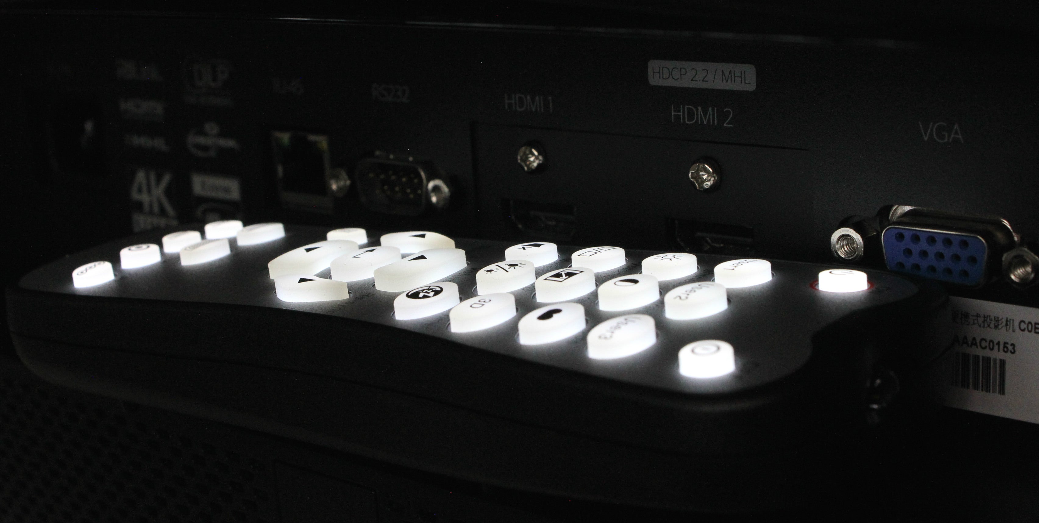 Close-up of Optoma UHD65 projector remote and input panel.