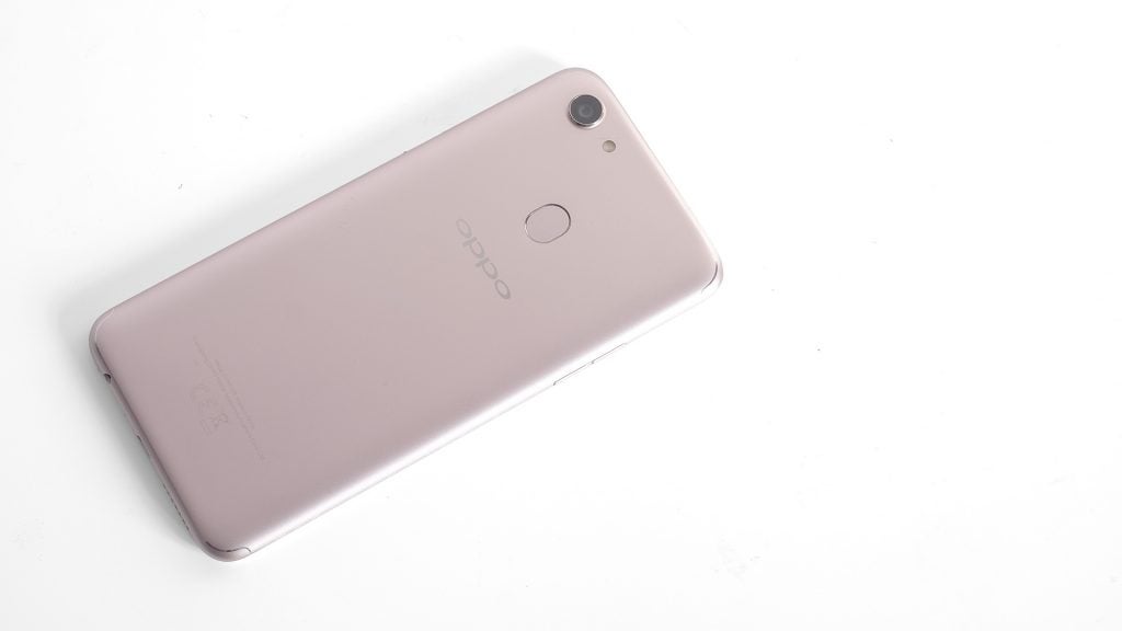Oppo F5 smartphone in rose gold color on white background.