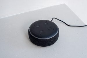 Gifts under £50 for him: Amazon Echo DotA black Motorola One Hyper held in hand displaying homescreen