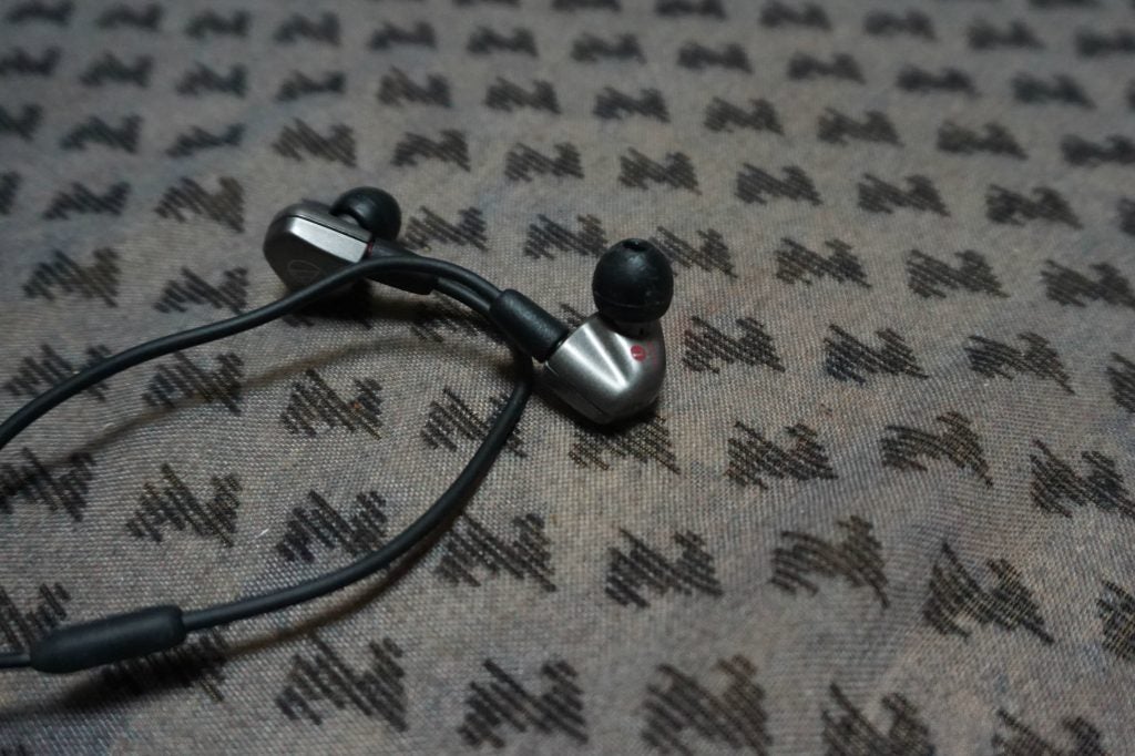 Audio-Technica ATH-LS70iS in-ear headphones on patterned fabric.