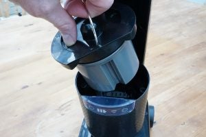 Hand removing dust container from Hotpoint vacuum cleaner