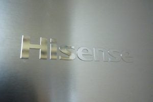 Close-up of Hisense logo on stainless steel fridge door.