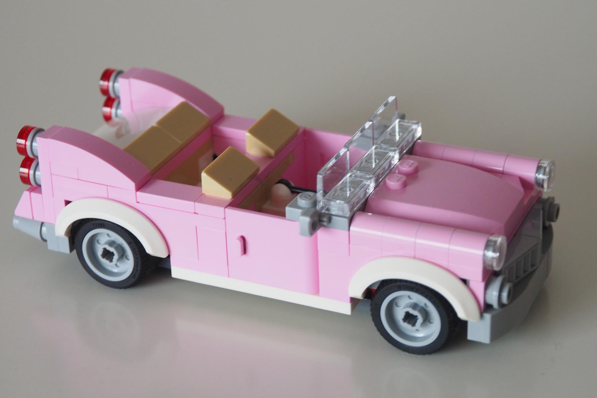 Pink LEGO vintage convertible car from a set.