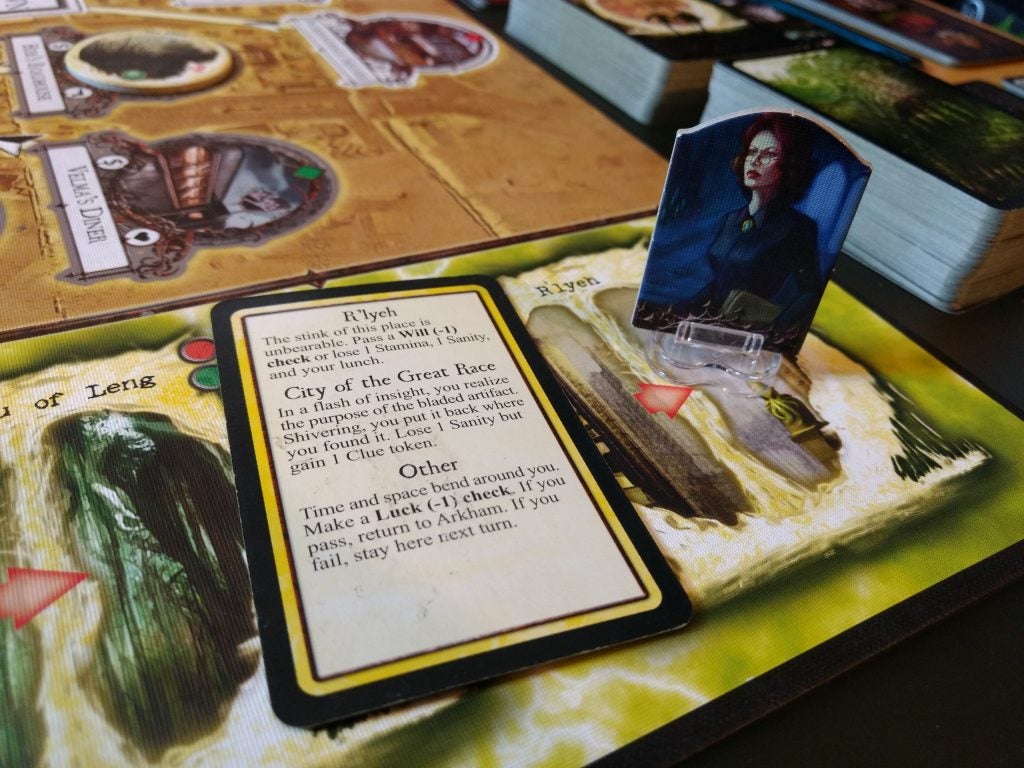 Arkham Horror game components and cards on table.