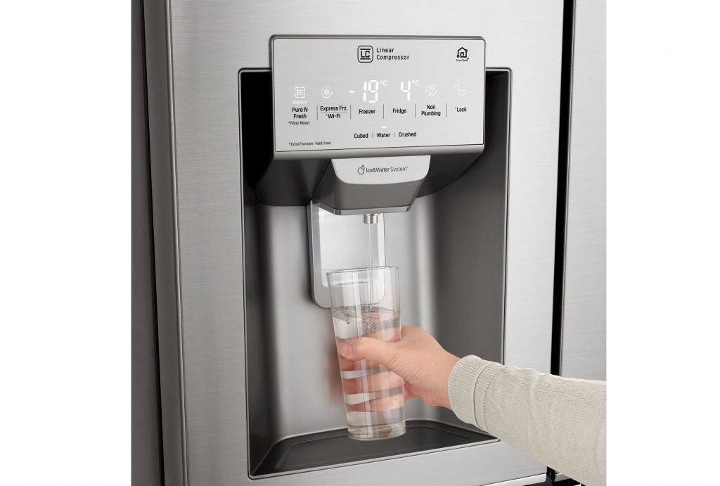 LG refrigerator's water dispenser in use.