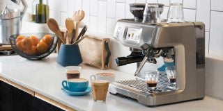 Sage Barista Touch espresso machine preparing coffee in a kitchen.