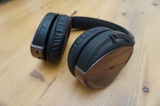 Asus ROG Strix Fusion 500 headphones on wooden background.