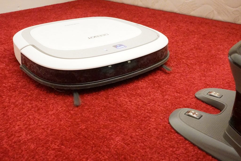 Ecovacs Deebot Slim2 robotic vacuum cleaner on red carpet.