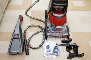 Bissell StainPro 10Bissell StainPro 10 carpet cleaner with accessories on floor.