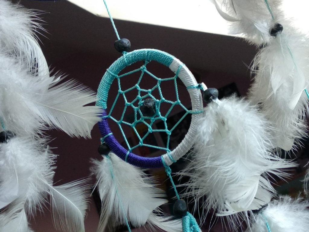 Photo taken by Xiaomi Mi A1 showcasing outdoor clarity.Close-up of a white and blue dreamcatcher with feathers.