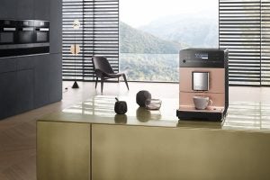 Miele CM5500 coffee machine on kitchen counter with scenic background.