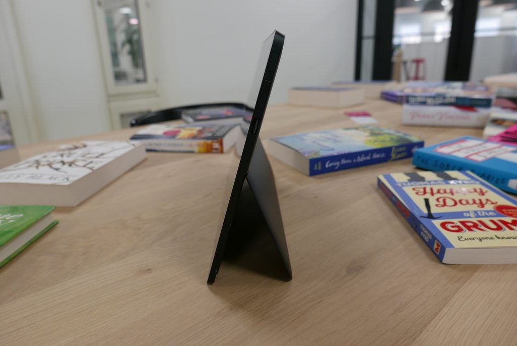 Eve V tablet on a desk with kickstand open and books in background.