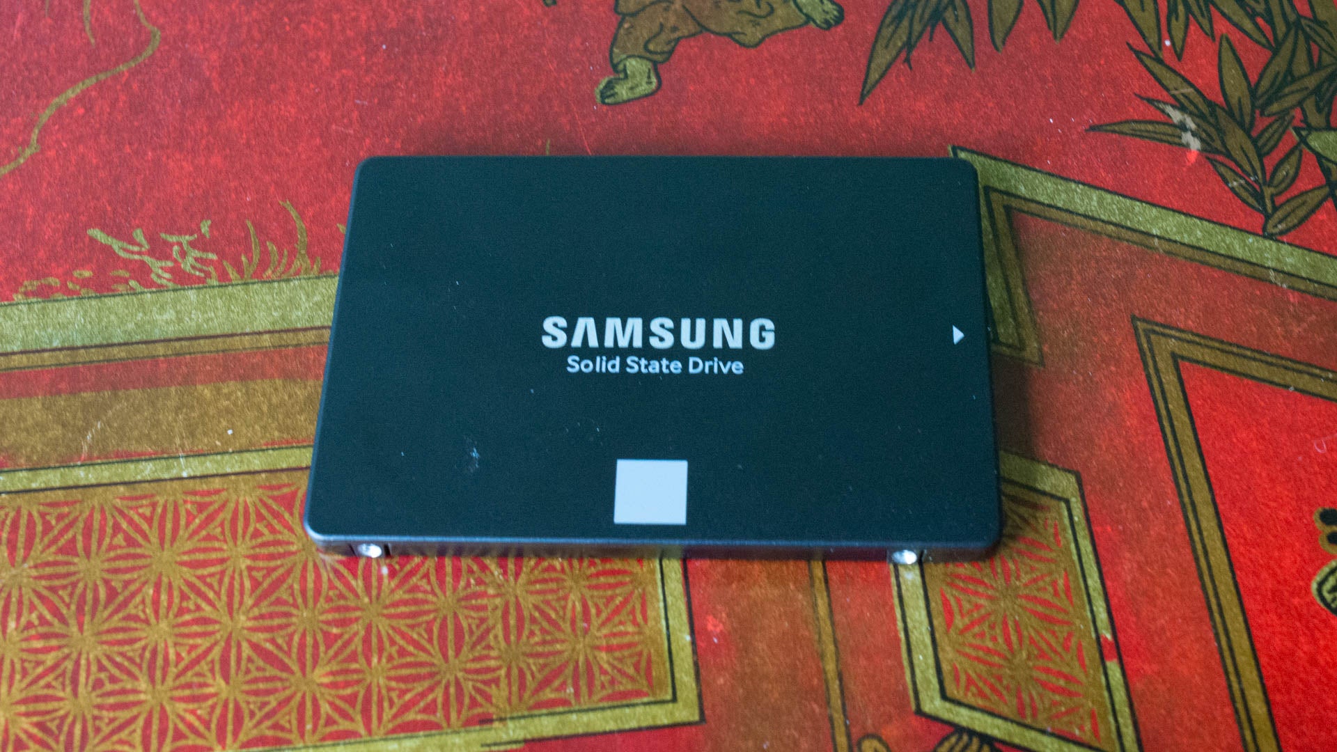 Samsung 860 Evo SSD on decorative red background.