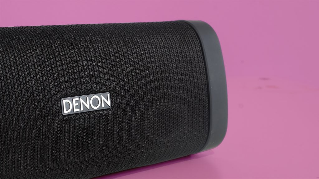 Close-up of Denon Envaya portable speaker on pink background.