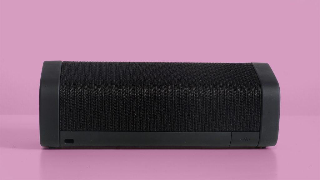 Black Denon Envaya Bluetooth speaker on pink background