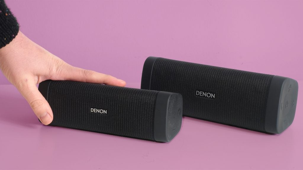 Hand placing Denon Envaya Bluetooth speaker on table