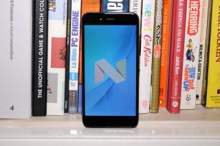 Xiaomi Mi A1 smartphone on a bookshelf with screen on.