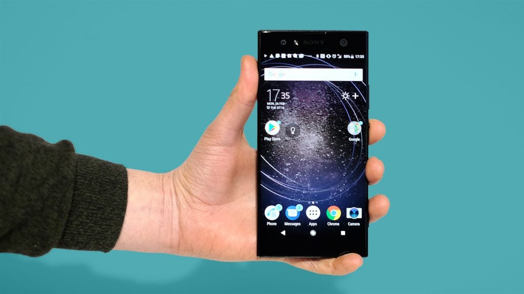 Hand holding a Sony XA2 Ultra smartphone with homescreen visible.