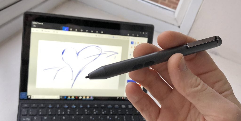 Hand holding stylus drawing on Acer Switch 3 tablet.
