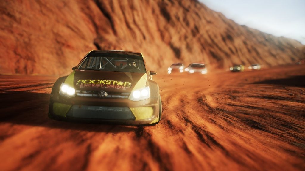 Rally cars racing on a dusty gravel track