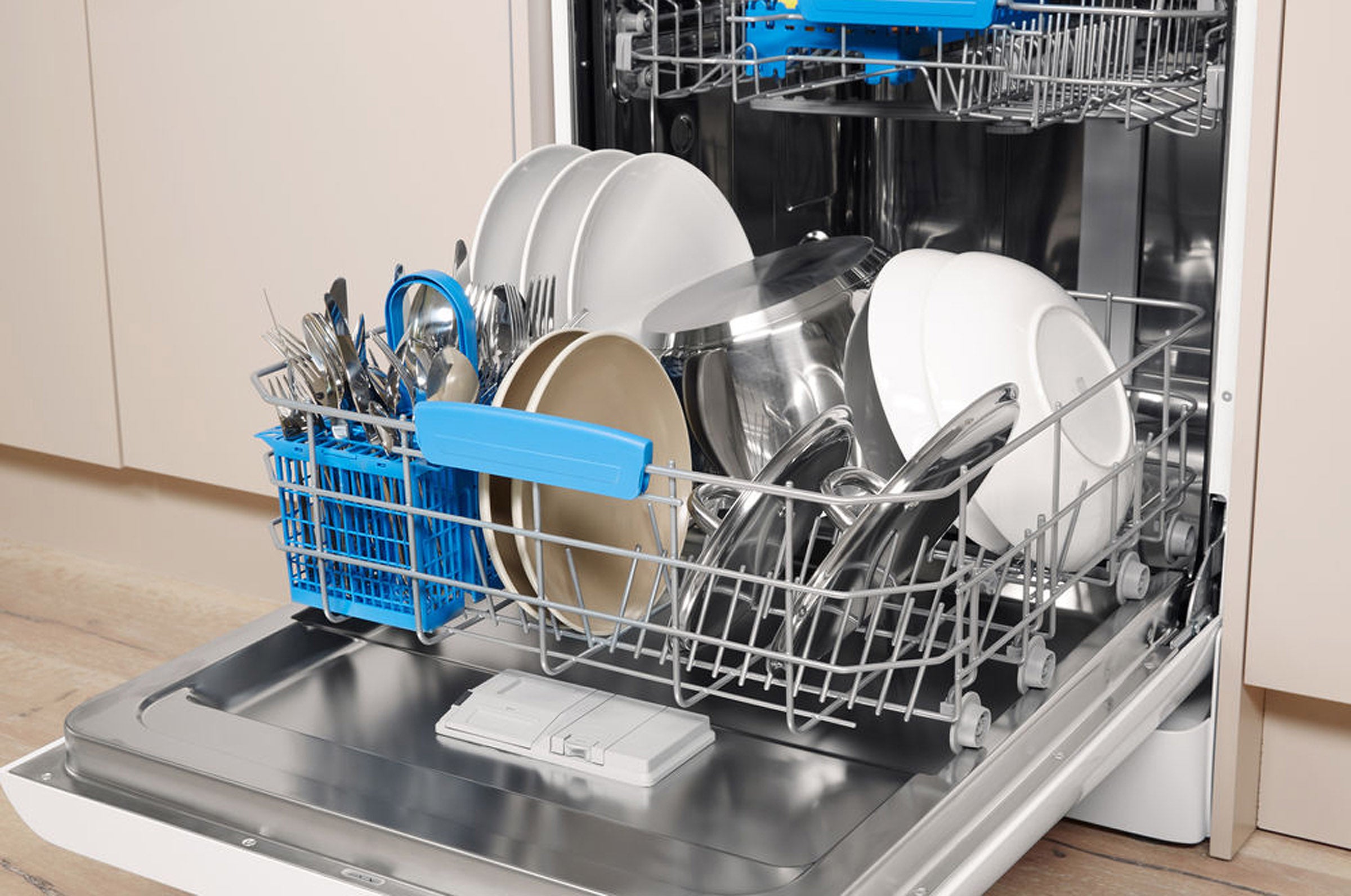 Open Indesit dishwasher with clean dishes inside.