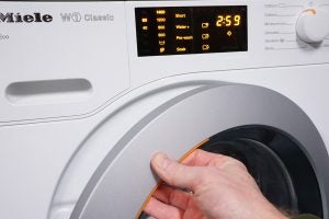 Miele WDB020 washing machine with active settings display.