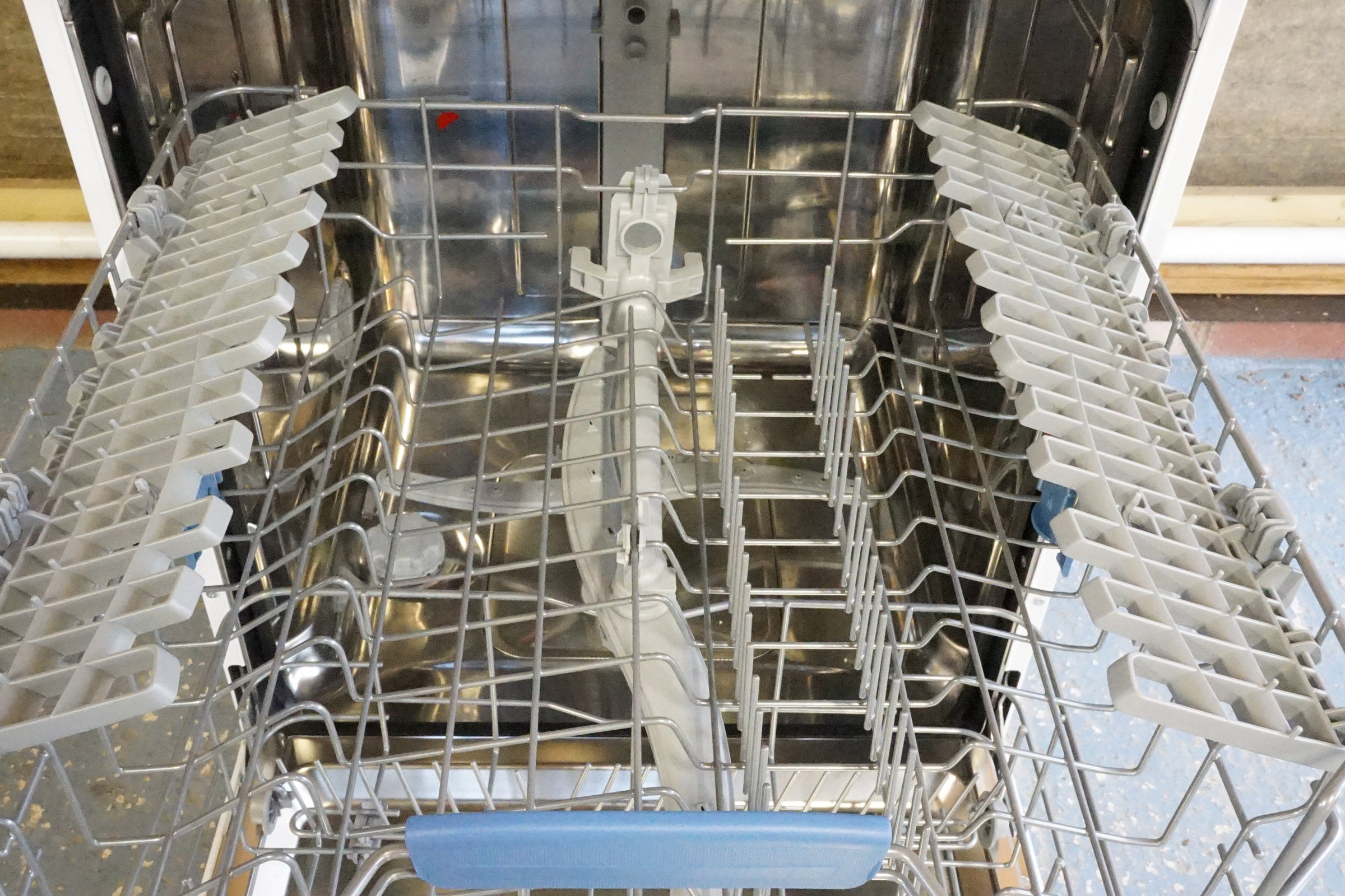 Interior view of an empty Indesit dishwasher model DFP 27T96 Z UK.
