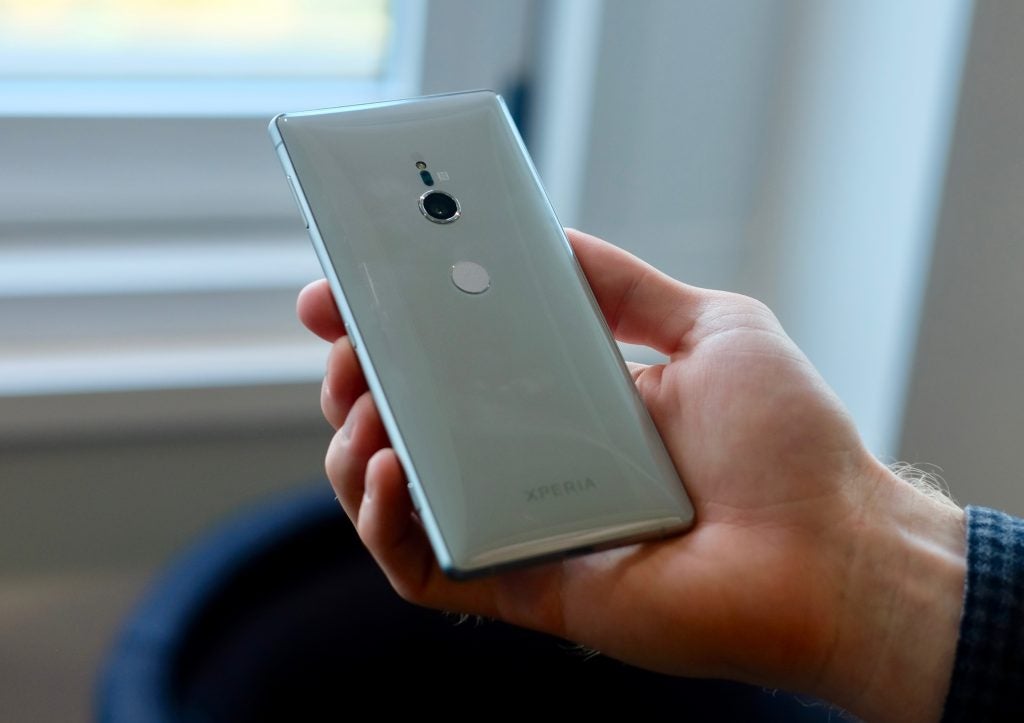 Person holding a Sony Xperia XZ2 smartphone from the back.