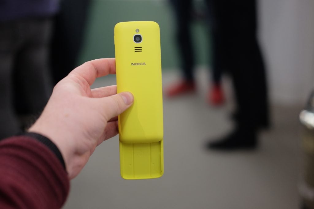Hand holding a yellow Nokia 8110 4G phone