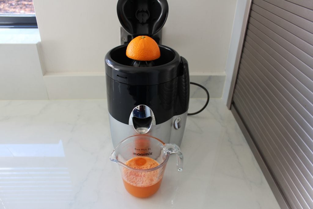 Magimix Le Duo Plus XL juicer with fresh orange juice.