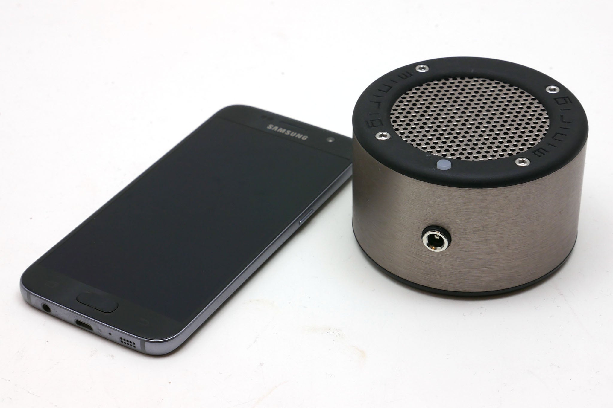 Minirig Mini portable speaker next to a Samsung smartphone.