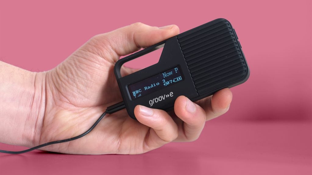 Hand holding Groov-e Rio portable radio with display on.