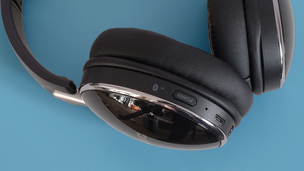 Close-up of JVC HA-S90BN wireless headphones on blue background.