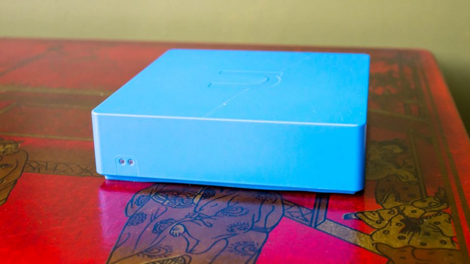Blue nCube Home smart home hub on a red table.