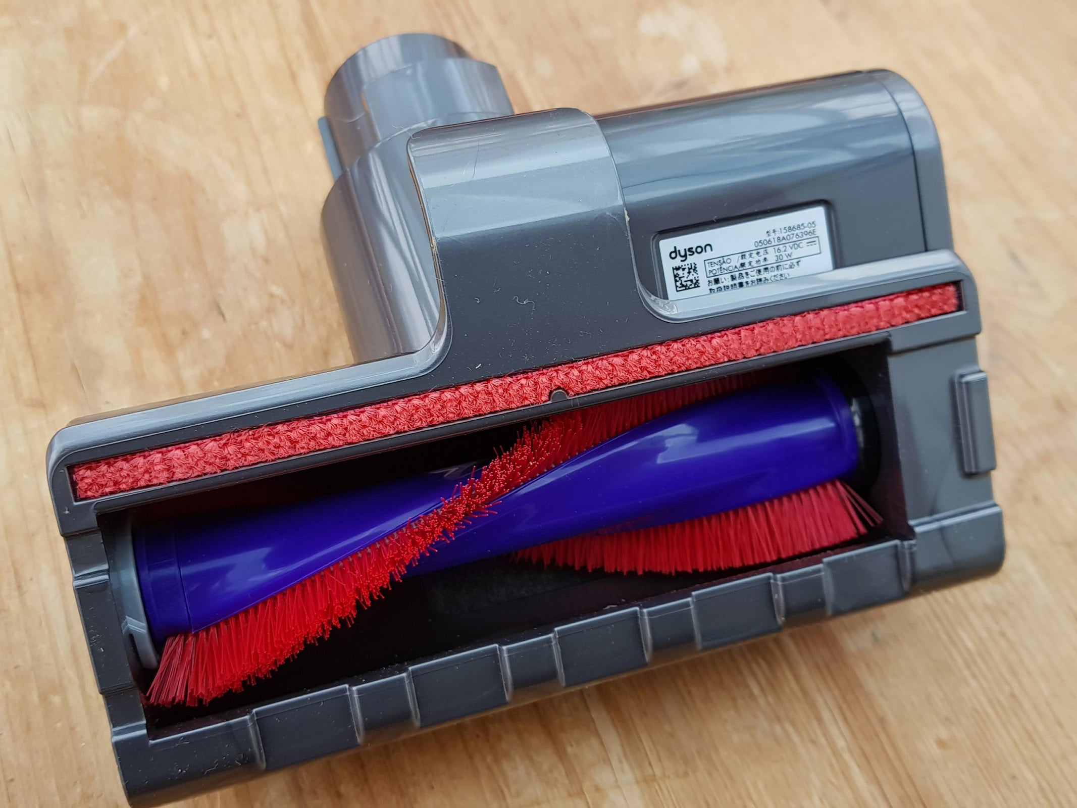 Dyson Cyclone V10 Absolute vacuum cleaner head on wooden surface