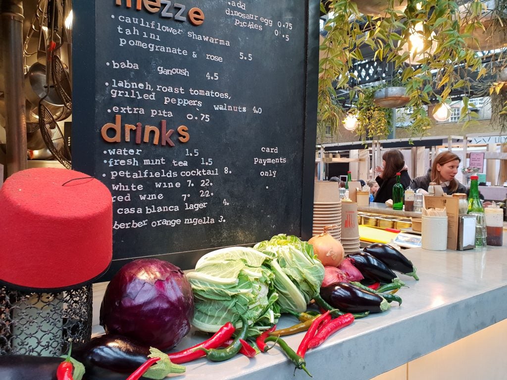 Vegetables on counter with menu board and cafe background