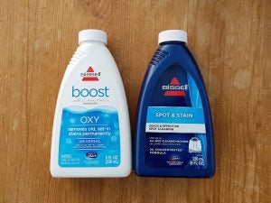 Bissell carpet cleaning products on wooden surface.
