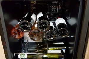 Currys Essentials CWC15B14 wine cooler filled with bottles.